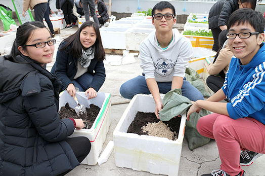 <em>Students mix planting soil in foam boxes scavenged from waste stations<br> (Source: Office of University General Education)</em>
