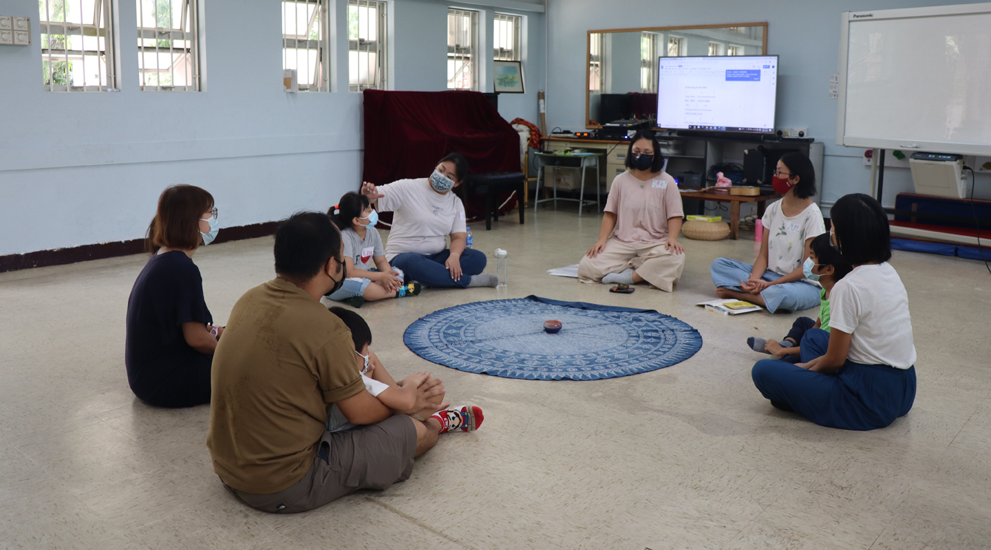 Families guided to meditate in a summer programme