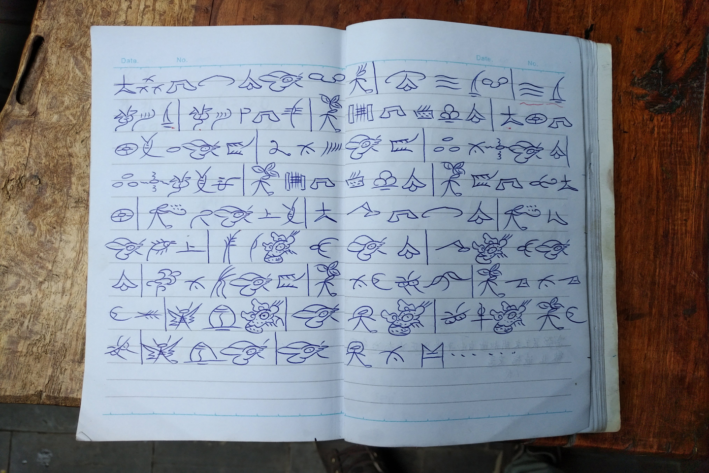 一個納西學生的記事簿，內有一首名曲的歌詞，以東巴文寫成<em>（相片由受訪者提供）</em>