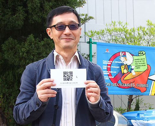 <em>Mr. Harold Yip, Executive Director of SSID, shows the QR code sticker (for display on trash bags) that will be distributed to CUHK units</em>