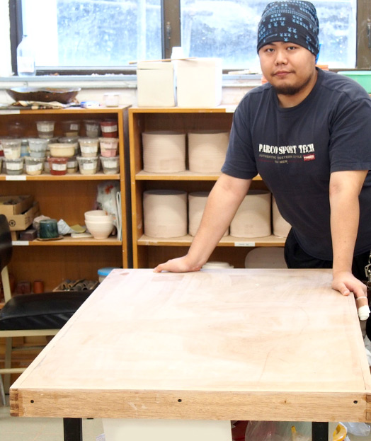 <em>林昆佑先生與他用FSC認證木材製成的陶瓷工作桌 </em>

