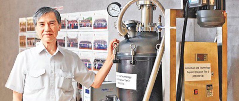 <em>Prof. Wong Po-keung with a 100-liter photocatalytic water purification unit </em>